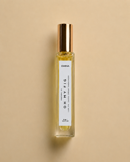 DAINA Oh My Fig perfume oil bottle with gold cap on a beige background